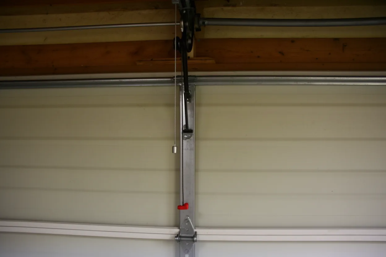 A garage door lift cable running to the top pulley