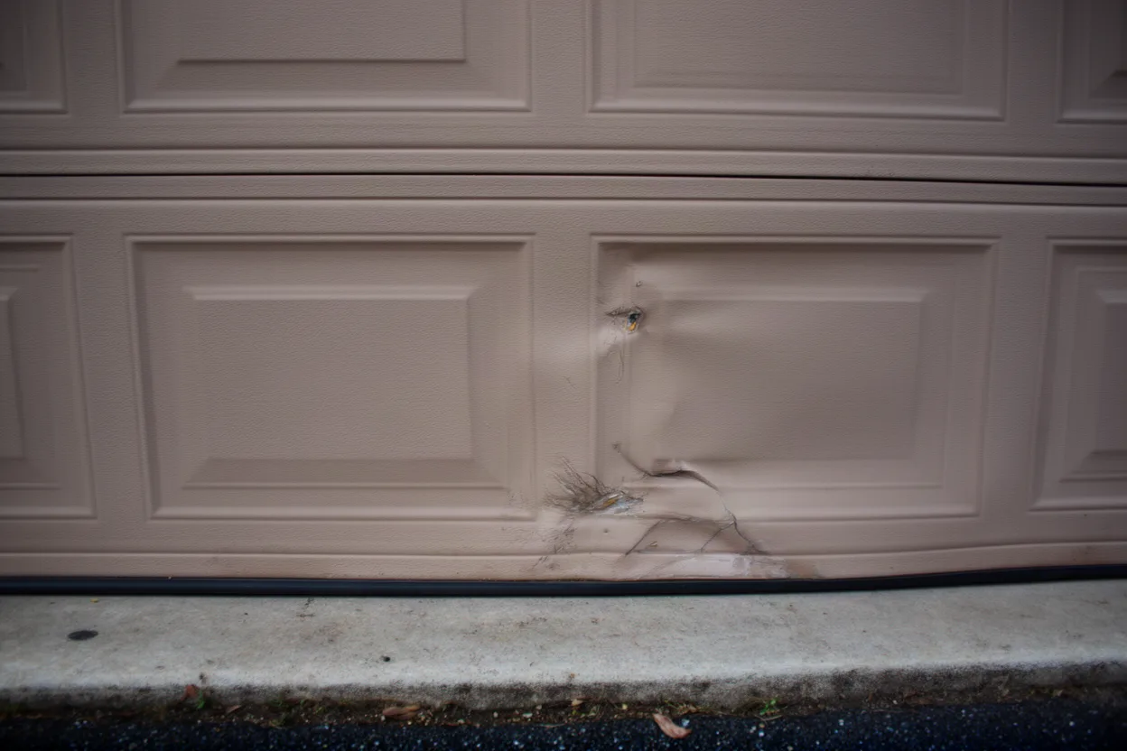 a dented lower panel on a sectional garage door