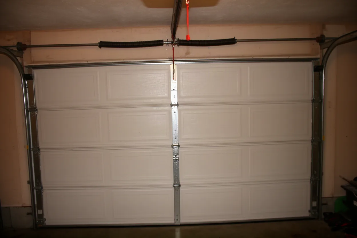 Torsion spring above a garage door opening